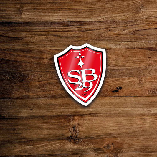 Autocollant en forme de bouclier rouge avec texte blanc et motif de croix.