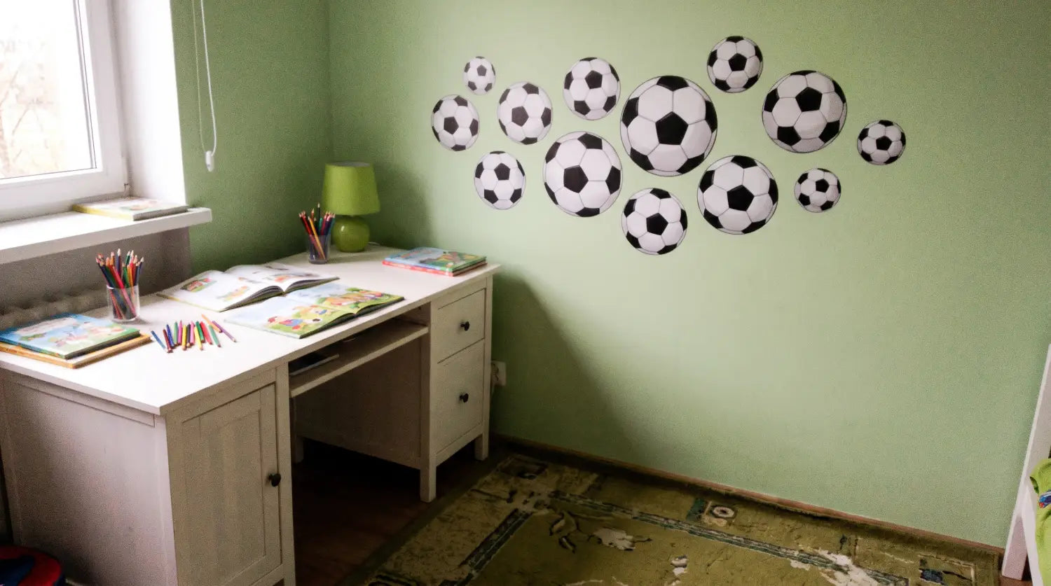 Chambre d'enfant décorée avec des stickers ballon de foot et un sticker prénom au-dessus du bureau