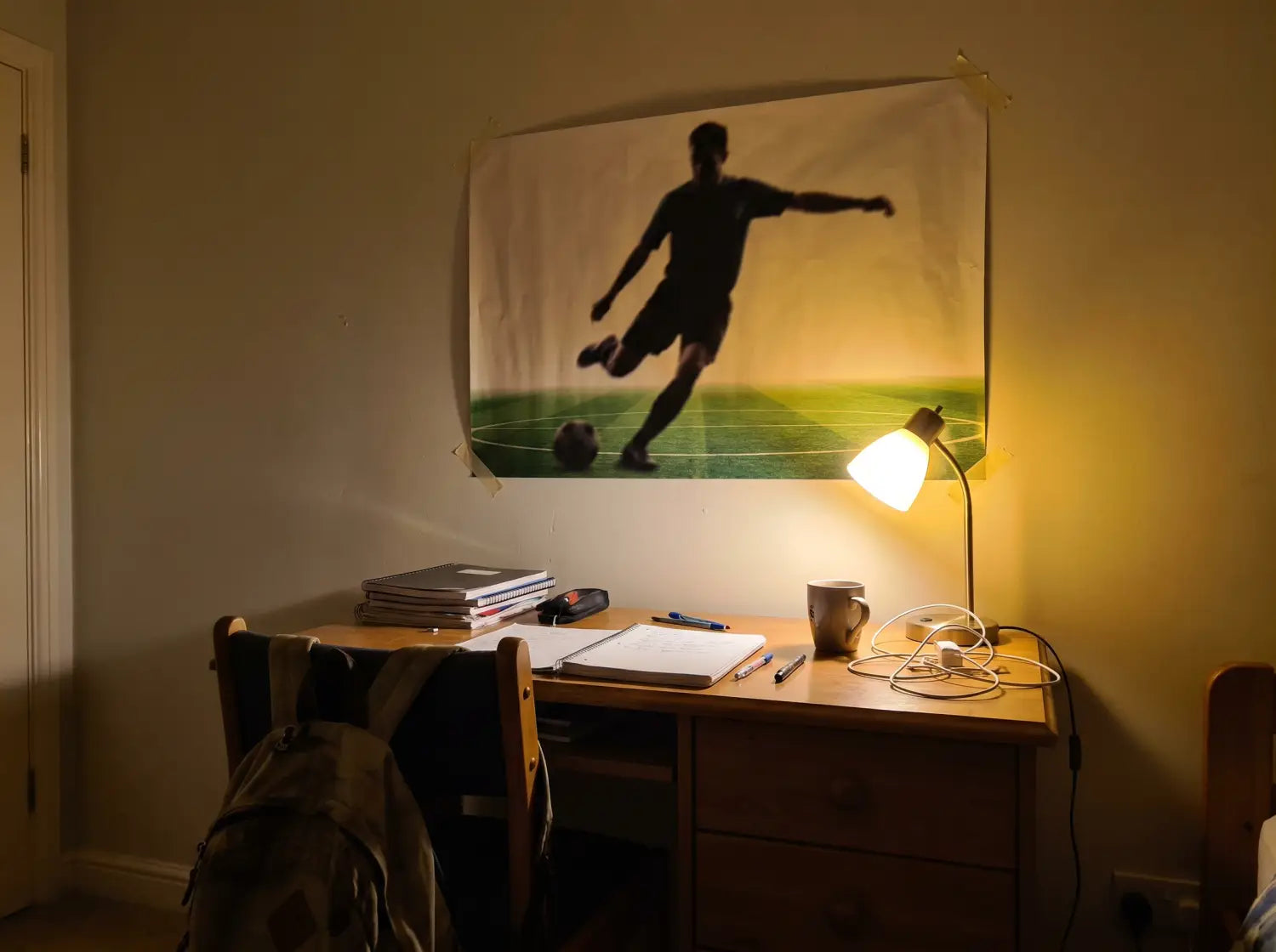 Gros plan d'un poster foot grand format au-dessus d'un bureau d'ado