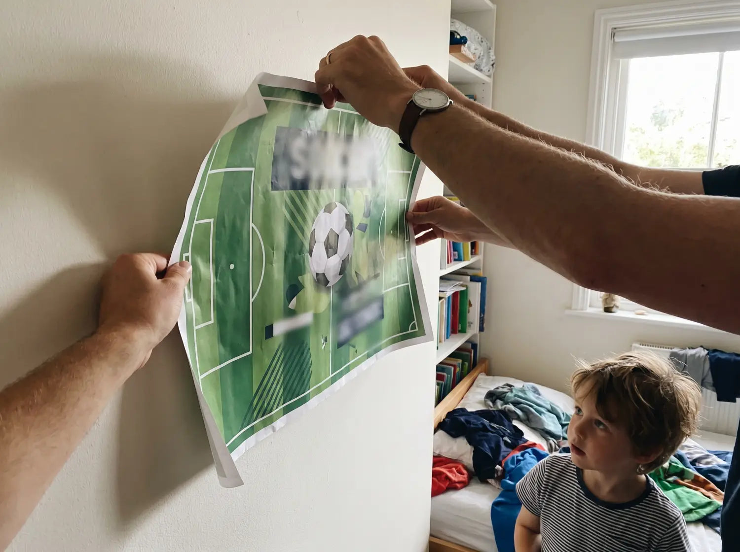 Parent tenant une affiche foot déroulée contre le mur avant de l'accrocher