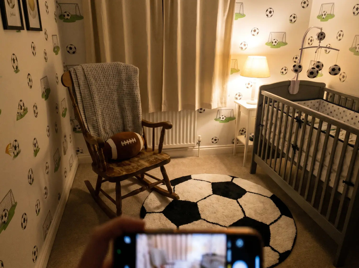 Détail d'un mur de chambre bébé avec papier peint football doux, herbe verte et nuages blancs