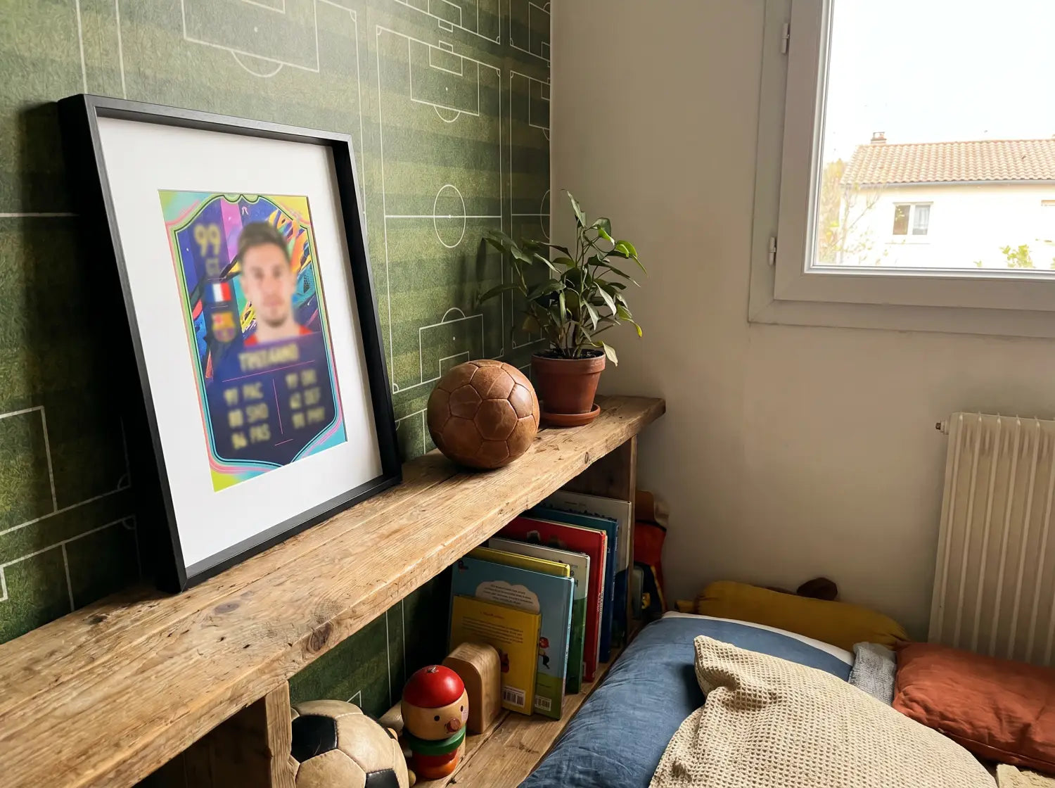 Carte de joueur encadrée sur une étagère dans une chambre d'enfant décorée sur le thème du football