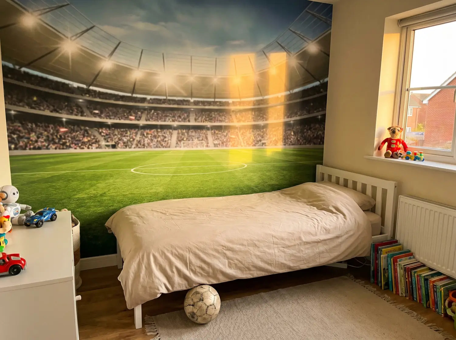 Lés de papier peint foot et outils de pose préparés au sol d'une chambre