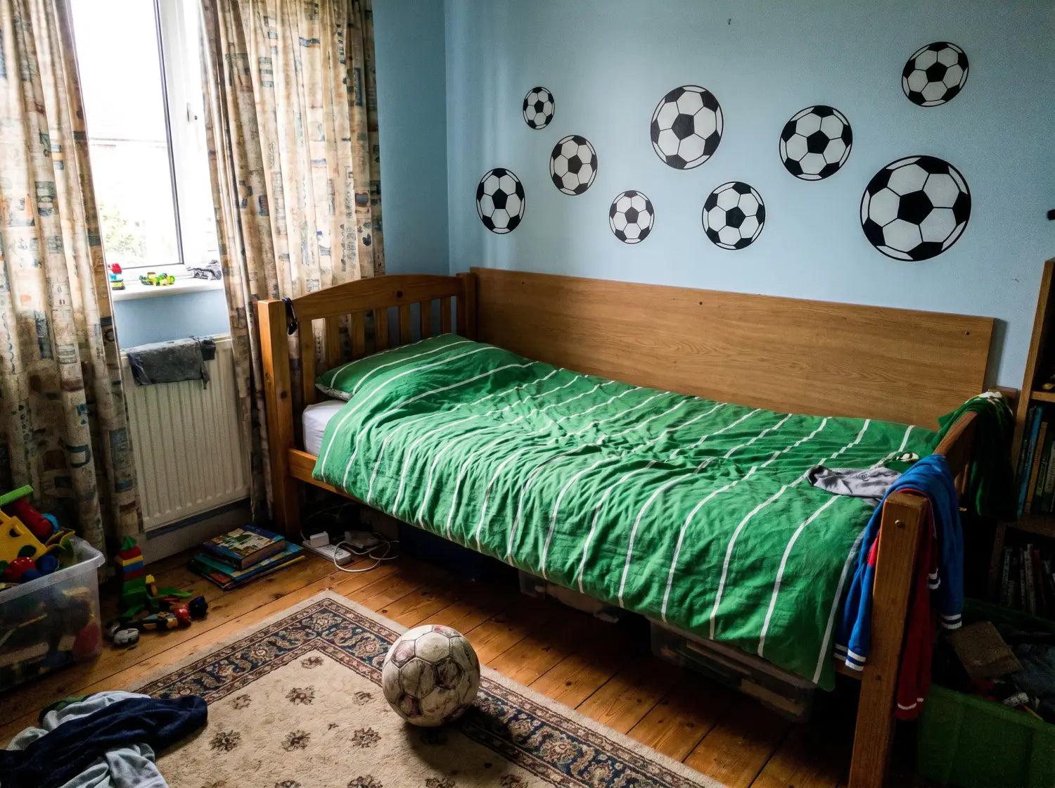 Chambre de garçon sur le thème du football avec stickers ballon au-dessus du lit