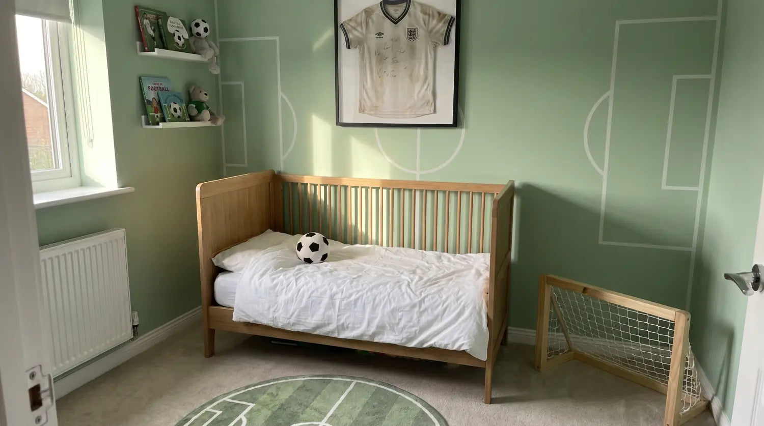 Vue d'ensemble d'une chambre de bébé thème football avec fauteuil et tapis ballon