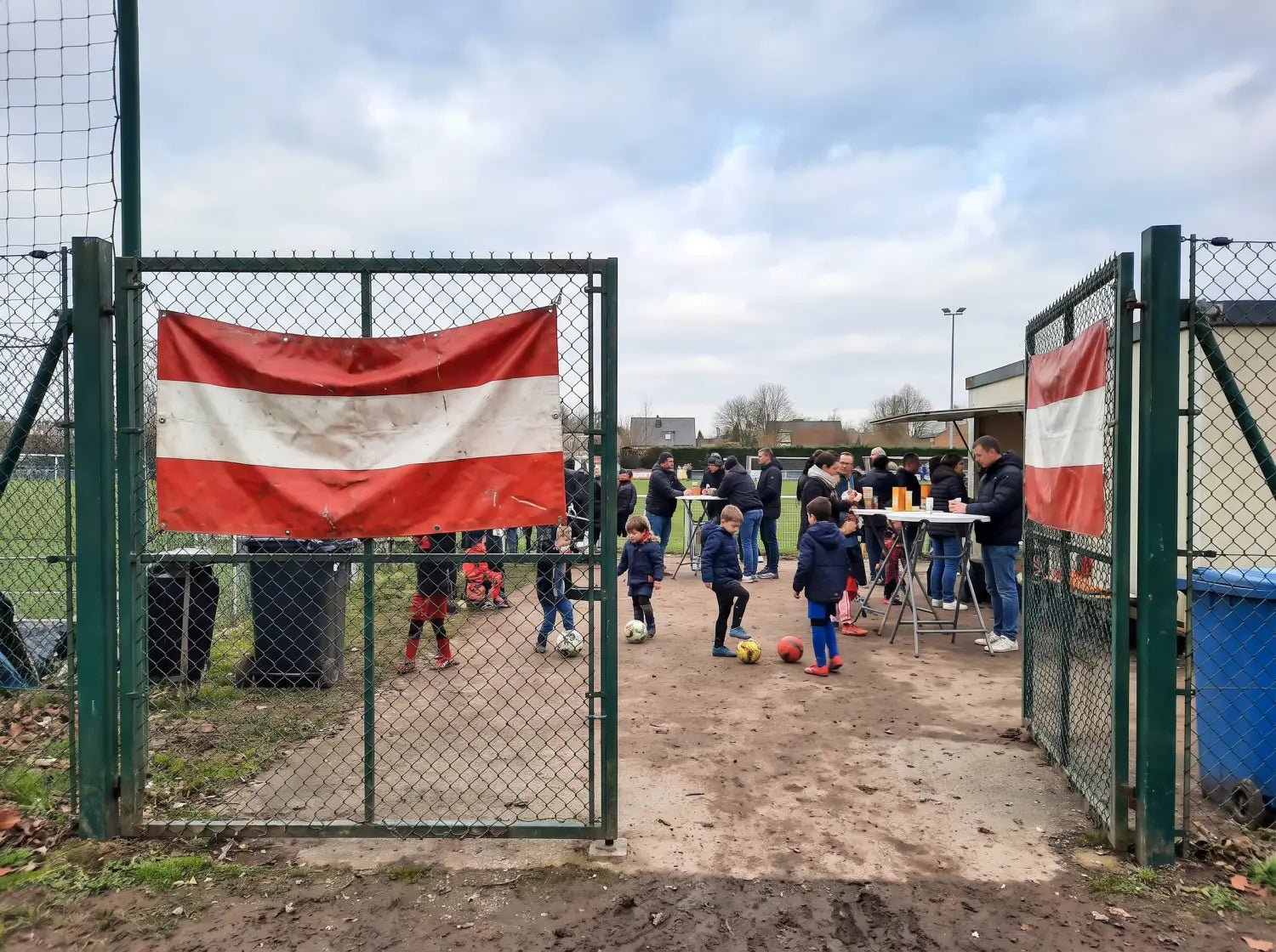 Deux banderoles de football colorées accrochées à l'entrée d'un stade amateur un jour de tournoi enfants