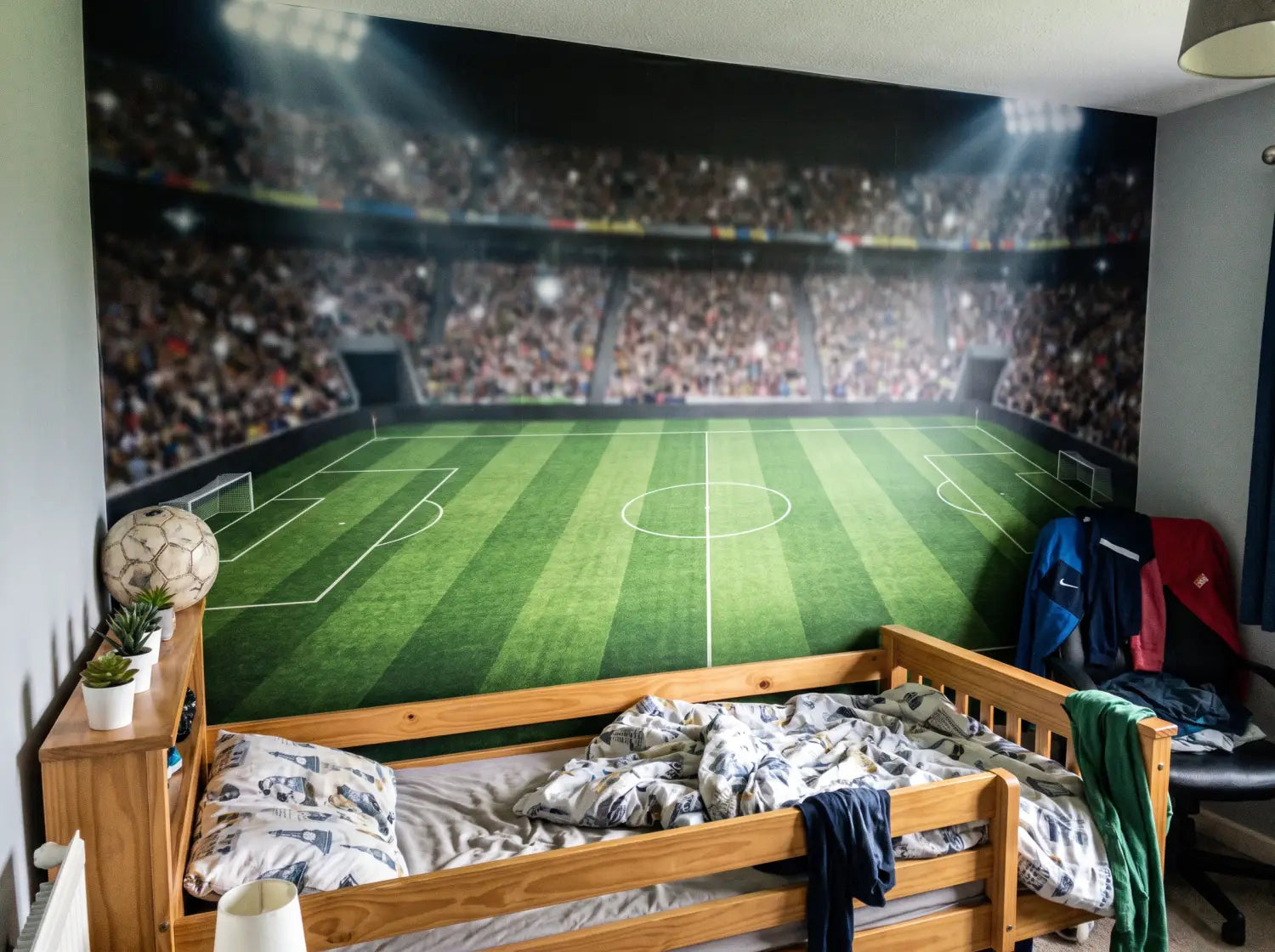 Mur de chambre de garçon habillé d'un papier peint panoramique sur le thème du football