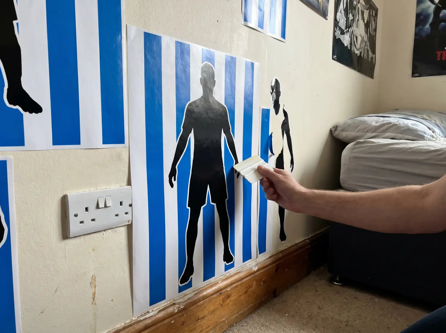 Pose d'un sticker mural football aux couleurs du club avec une raclette dans une chambre d'ado