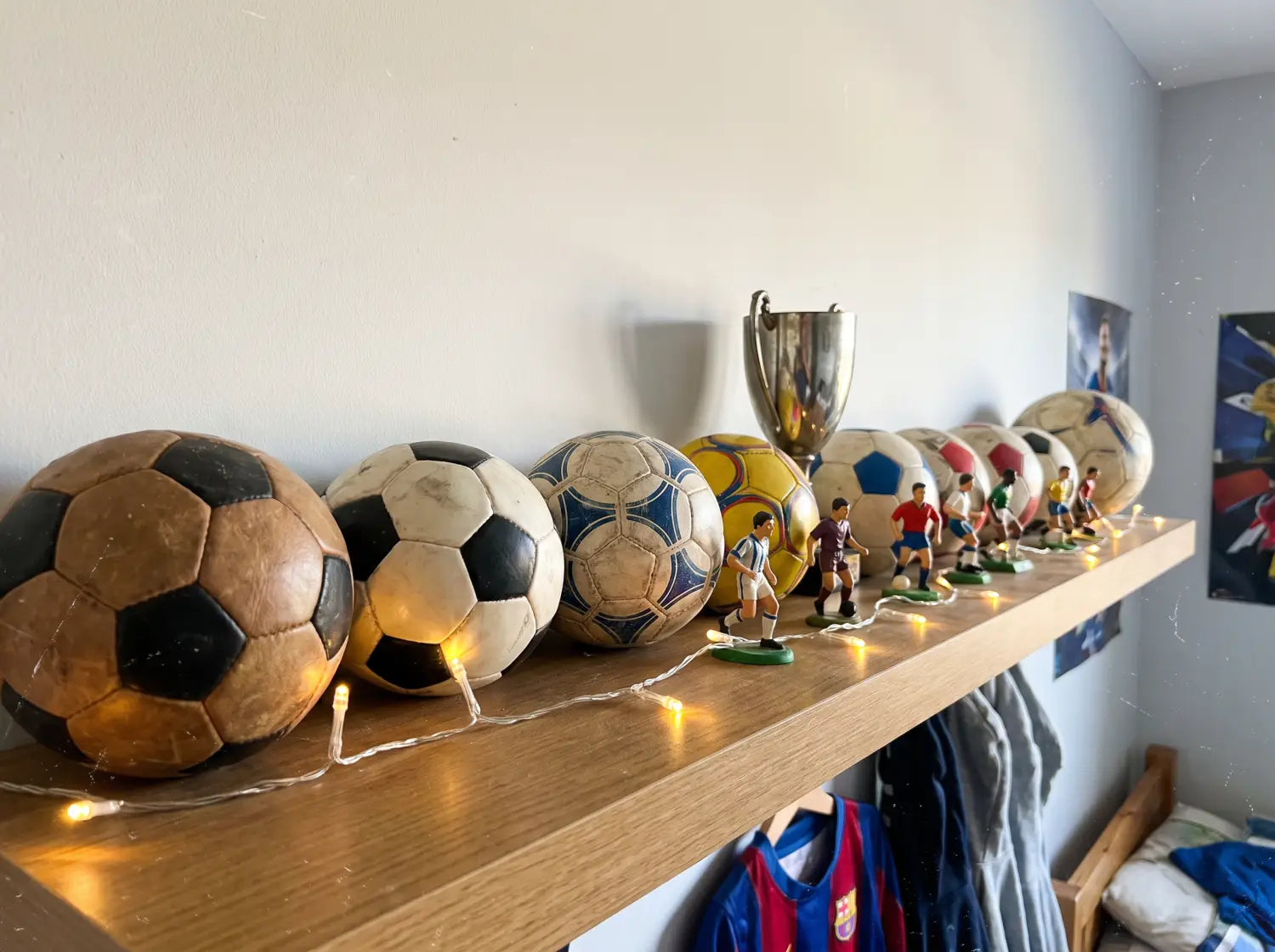 Étagère avec mini ballons, trophée et figurines dans une chambre foot