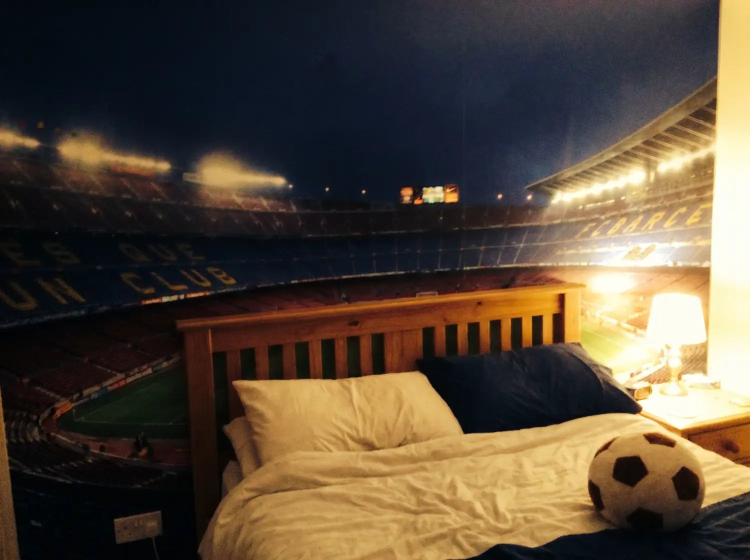 Tête de lit avec papier peint stade de foot de nuit dans une chambre d'enfant